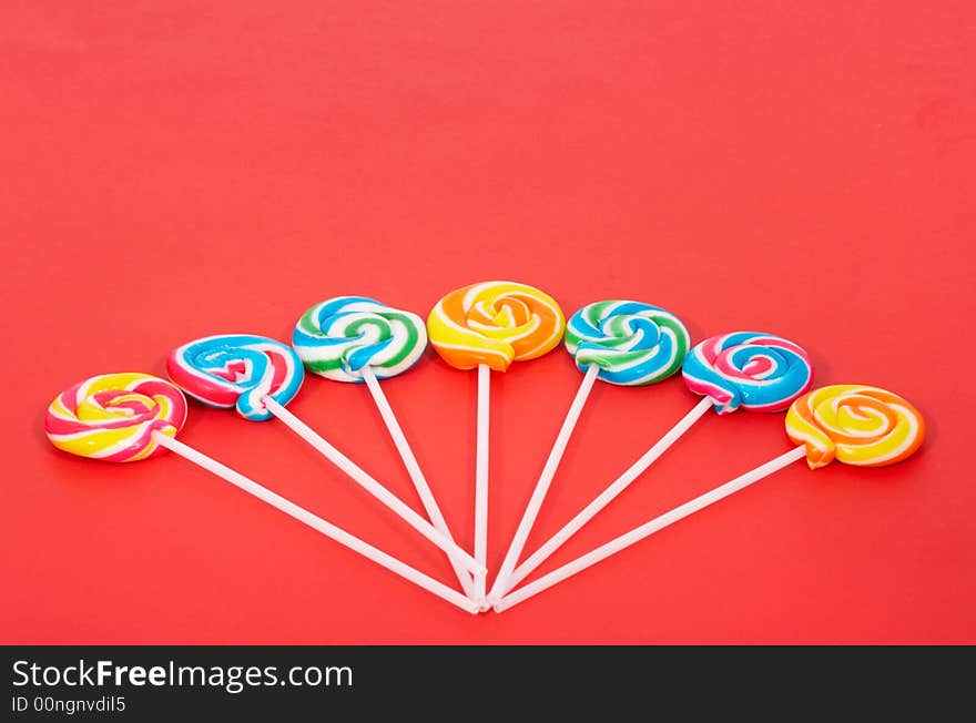 Twirl lollipop candies over a red background