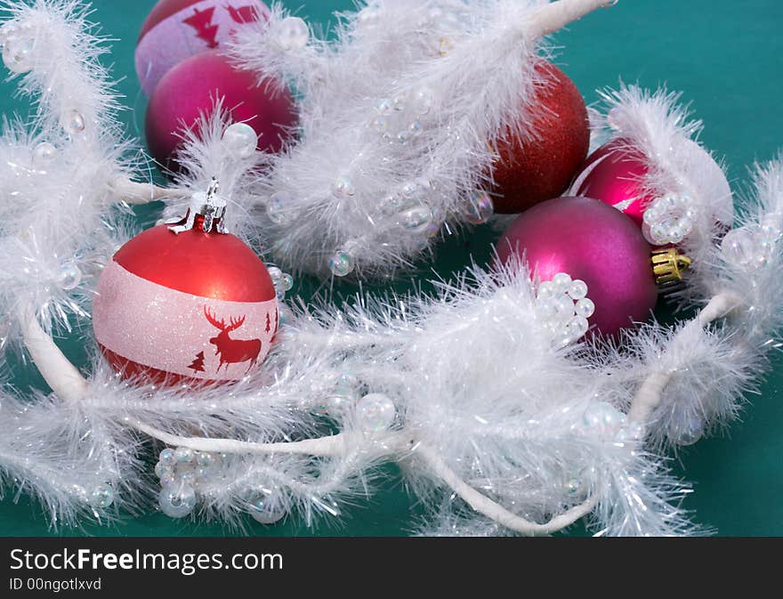 A red Christmas bauble and white garland. A red Christmas bauble and white garland