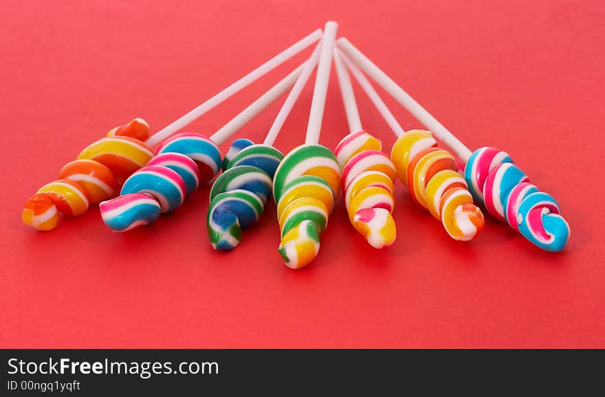 Twirl lollipop candies over a red background