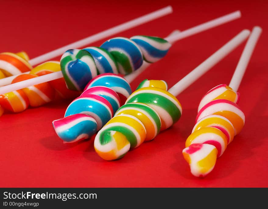 Twirl lollipop candies over a red background