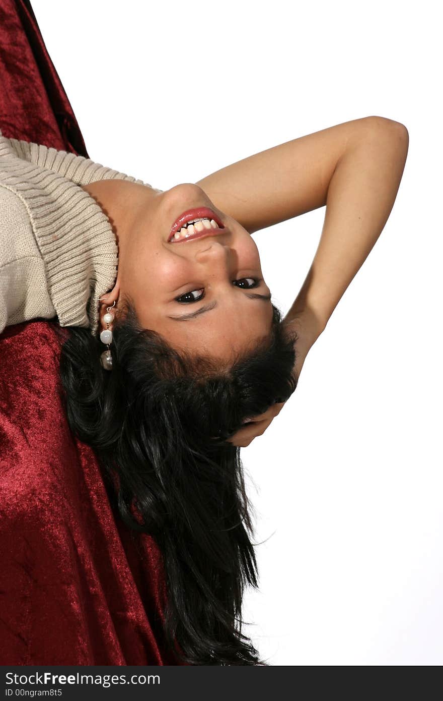 Attractive young woman in a beige dress leaning back sideways over a chair. Attractive young woman in a beige dress leaning back sideways over a chair