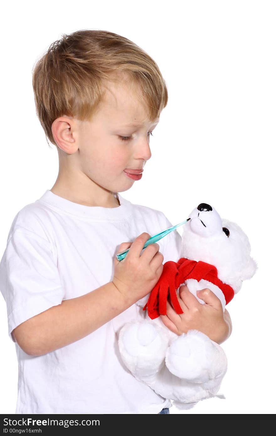 Cute young boy using a thermometer on his stuffed bear. Cute young boy using a thermometer on his stuffed bear