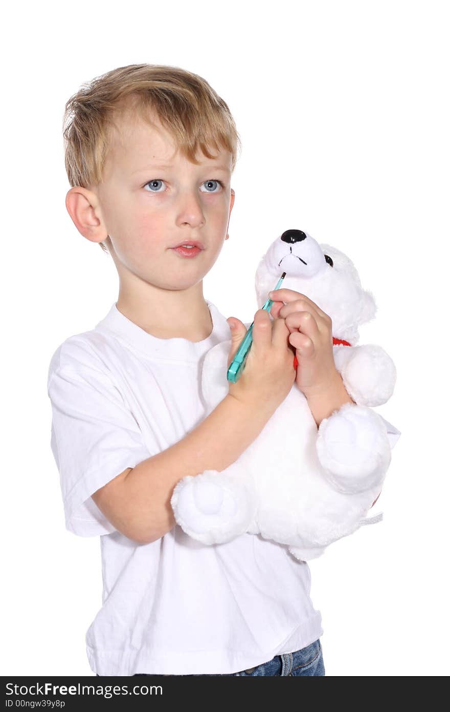 Cute young boy using a thermometer on his stuffed bear. Cute young boy using a thermometer on his stuffed bear