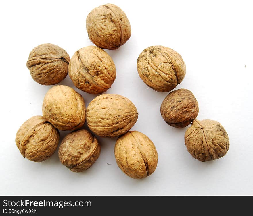 Eleven walnuts on white.  
Close together with some shade.