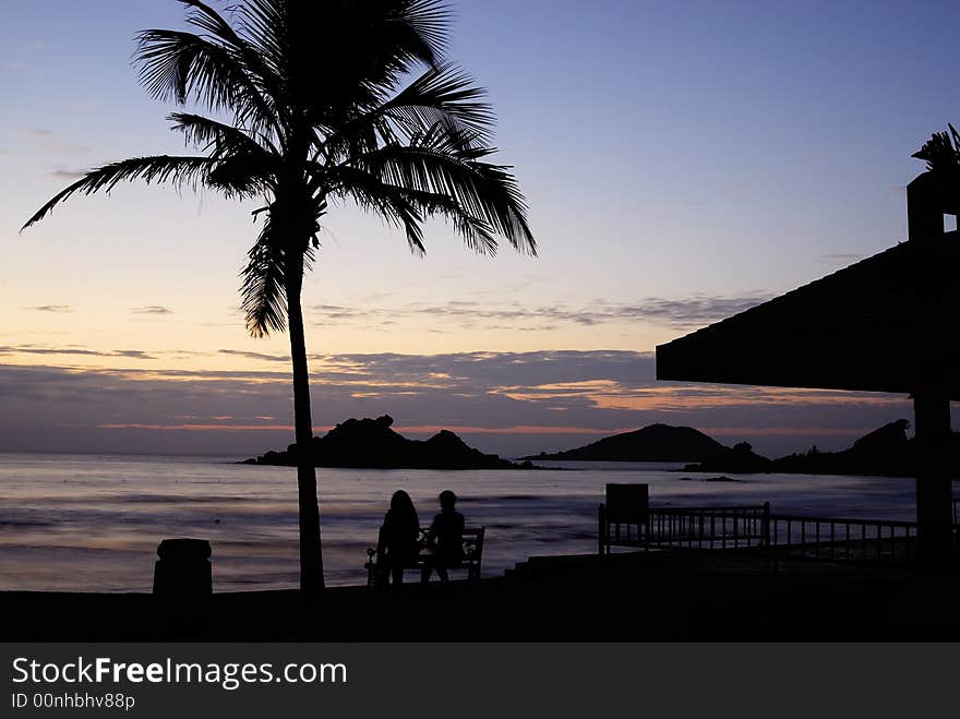 Cloudy sunrise at seaside with silhouette palm tree or coconut tree