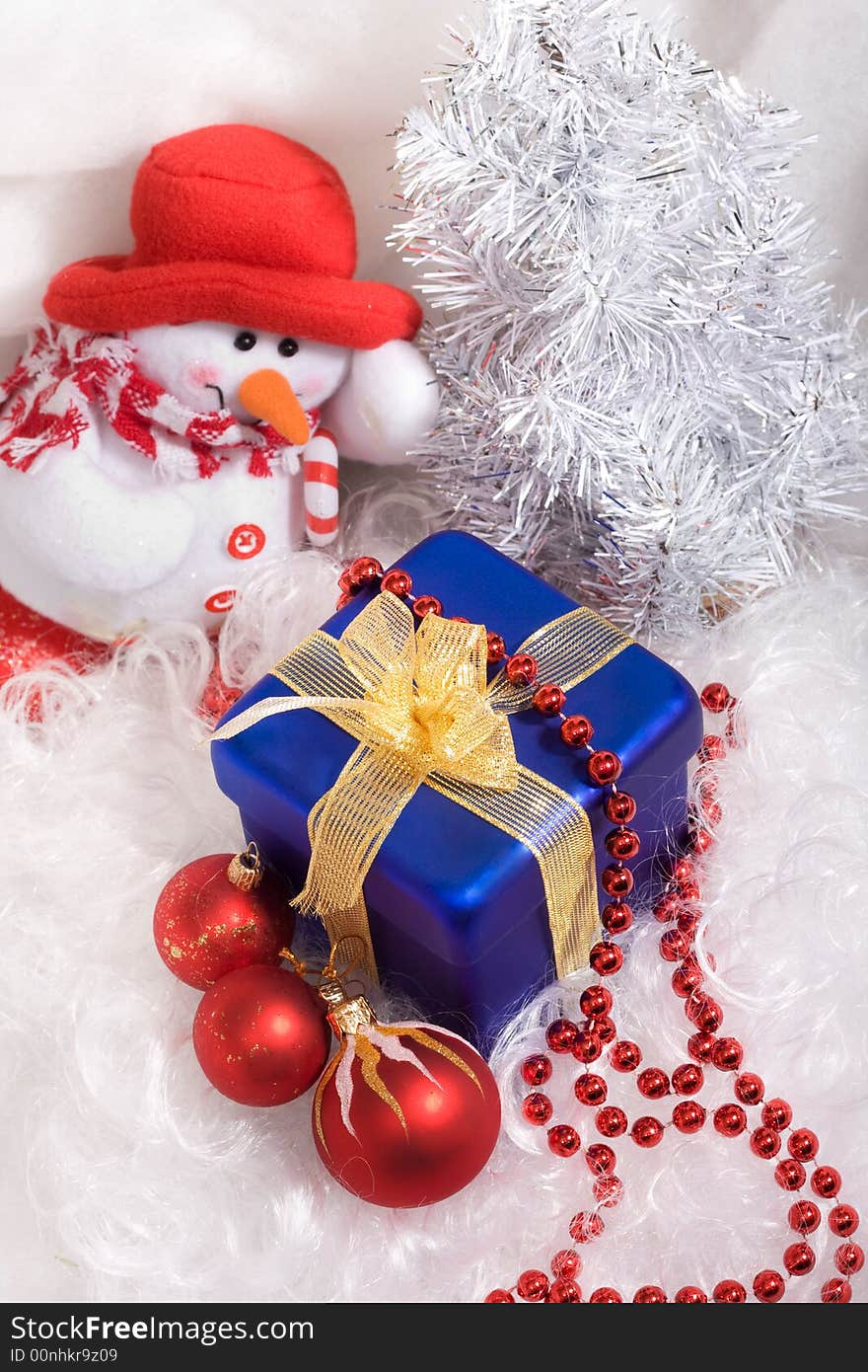 Red christmas balls and red beads, blue box with gift, and snowman. Red christmas balls and red beads, blue box with gift, and snowman