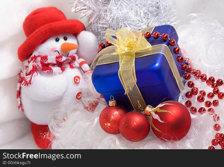 Red christmas balls and red beads, blue box with gift, and snowman. Red christmas balls and red beads, blue box with gift, and snowman