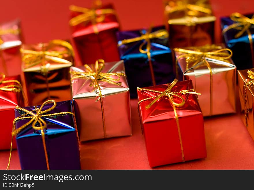 Small boxes with gifts on red background, low DOF