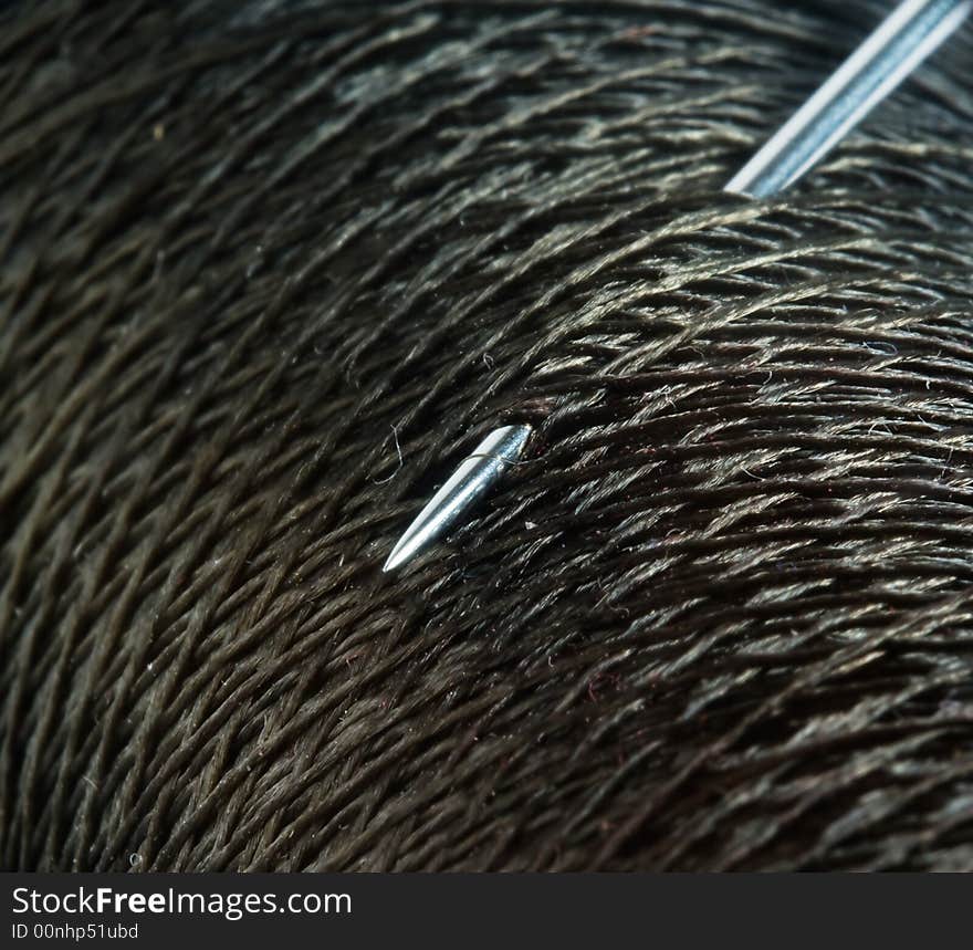 Needle in the spool of thread. Macro.