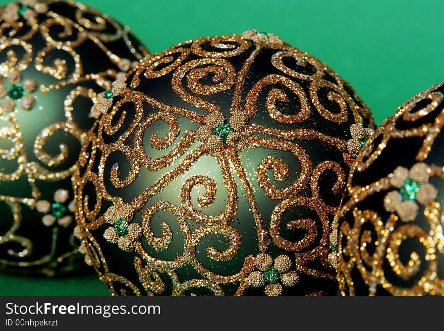 Christmas balls with gold ornament on the green background. Christmas balls with gold ornament on the green background