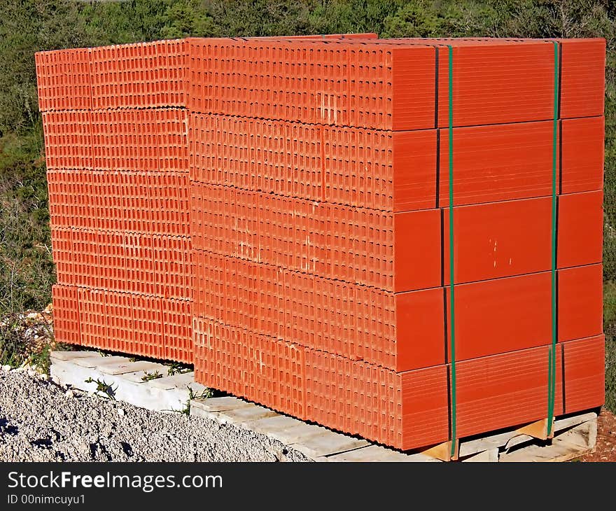 Two stacks of red bricks ready to be used in a construction site. Two stacks of red bricks ready to be used in a construction site