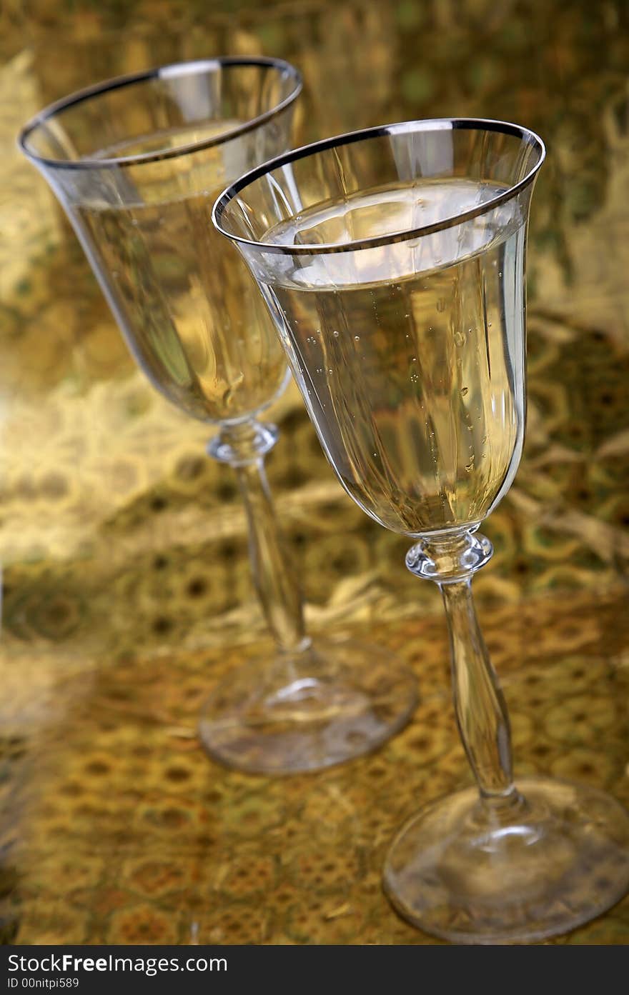 Two glasses of champagne on golden background. Two glasses of champagne on golden background