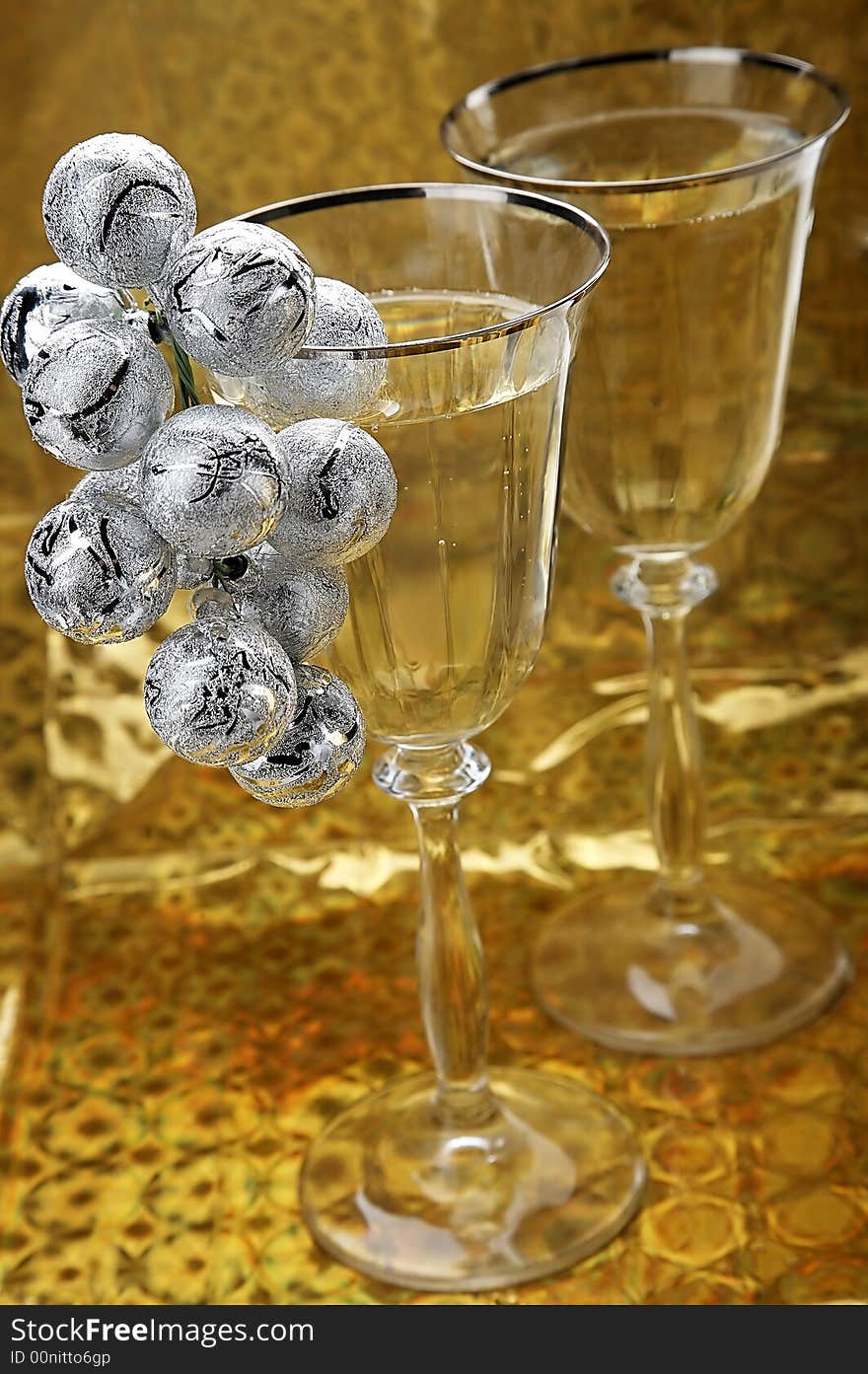 glasses of champagne with christmas decoration on golden background. glasses of champagne with christmas decoration on golden background