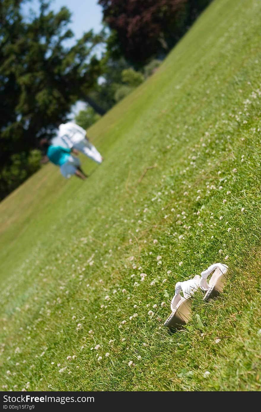 African American couple strolling through a grassy field, the woman's shoes left behind.  Shallow DOF with focus on shoes. African American couple strolling through a grassy field, the woman's shoes left behind.  Shallow DOF with focus on shoes.