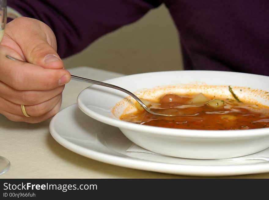 Plate with Russian soup -borshch and man's hand. Plate with Russian soup -borshch and man's hand