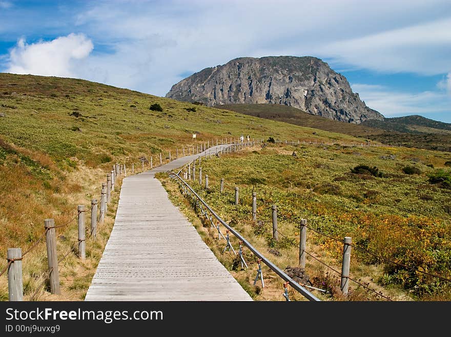 Mountain view over a plato with orange grass and wooden walk path. Mountain view over a plato with orange grass and wooden walk path