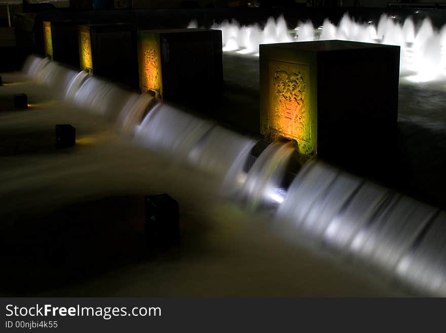 Water fountain at night with colorful lights and cubes with ornament