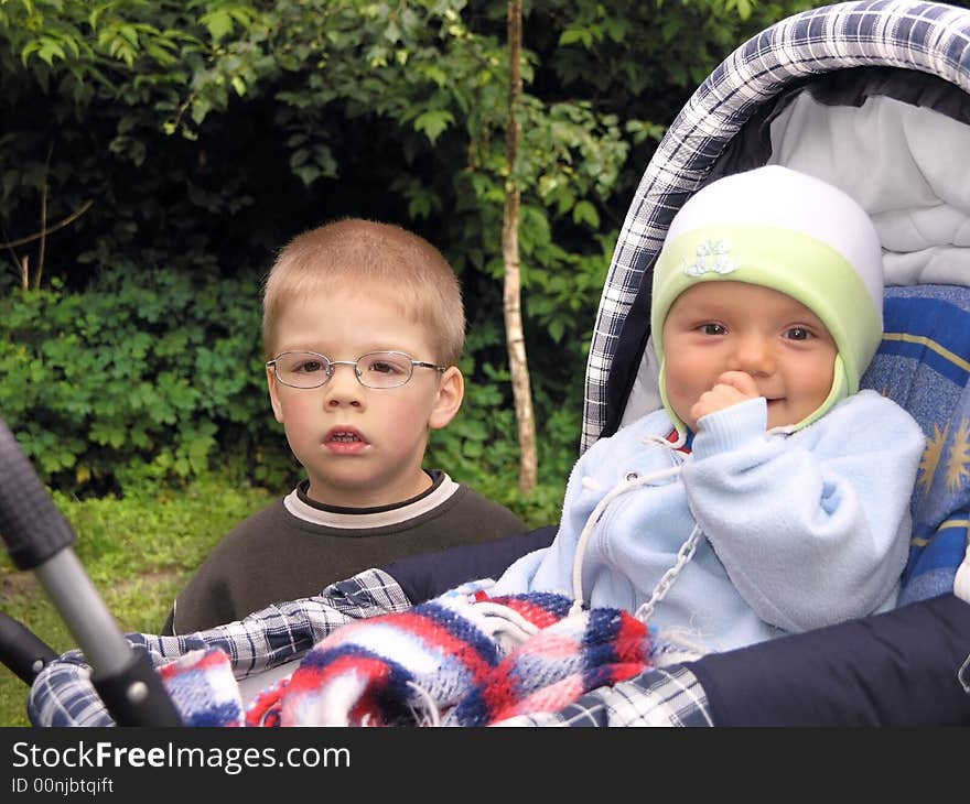 Brothers playing in the park while his dad watches