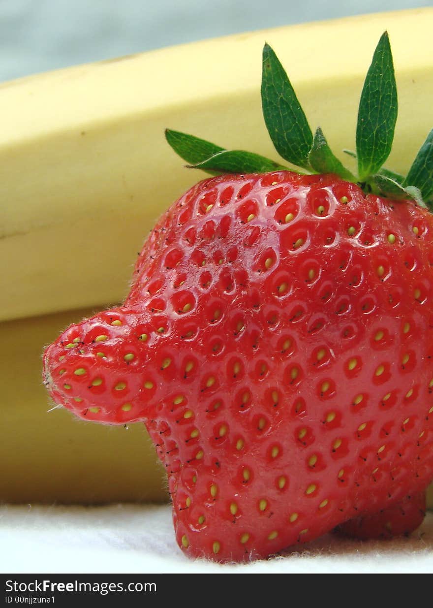 Red-nosed strawberry with banana background