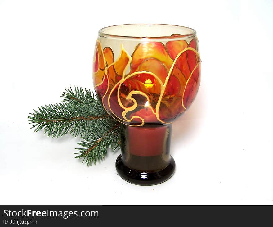 Hand-painted candlestick with burning candle and fir-tree branch as Christmas decoration