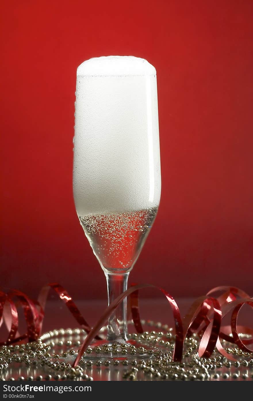 Still life with glass with champagne on the red background