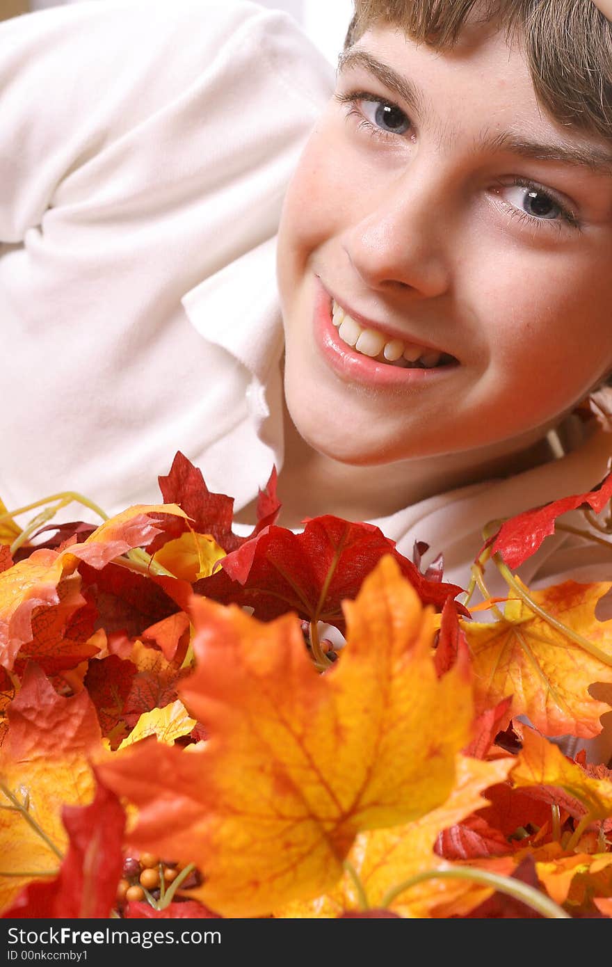 Photo of a young boy in fall leaves vertical