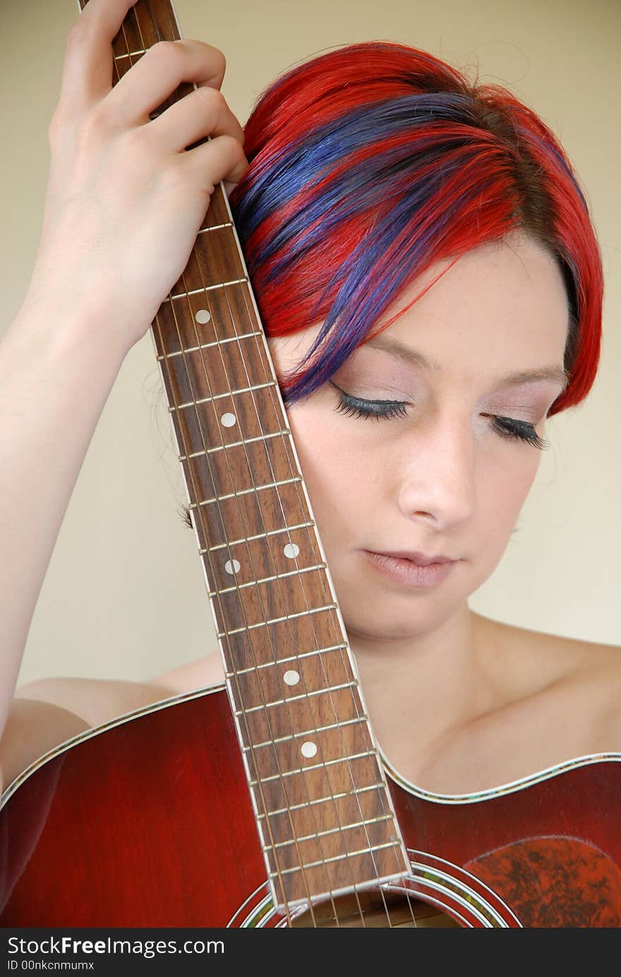 Alternative model with red hair holds guitar. Alternative model with red hair holds guitar.