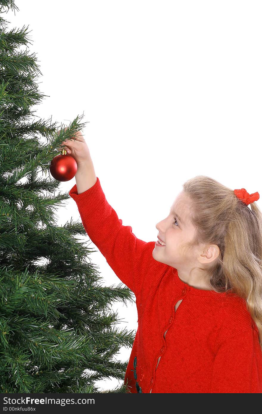 Child hanging ornament on tree vertical