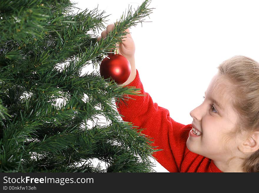 Child hanging ornament on tree