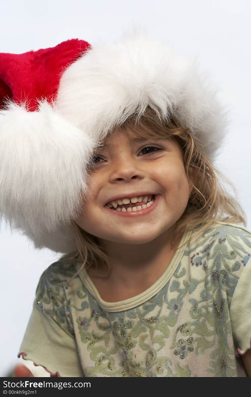 A young girl smiling in santa hat. A young girl smiling in santa hat