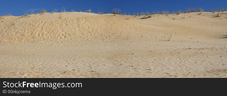 Panoramic shot of sand dunes, against deep blue sky. Panoramic shot of sand dunes, against deep blue sky