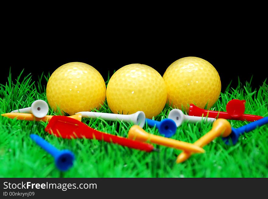 Golfball in orange tee, green fairway, isolated on black background