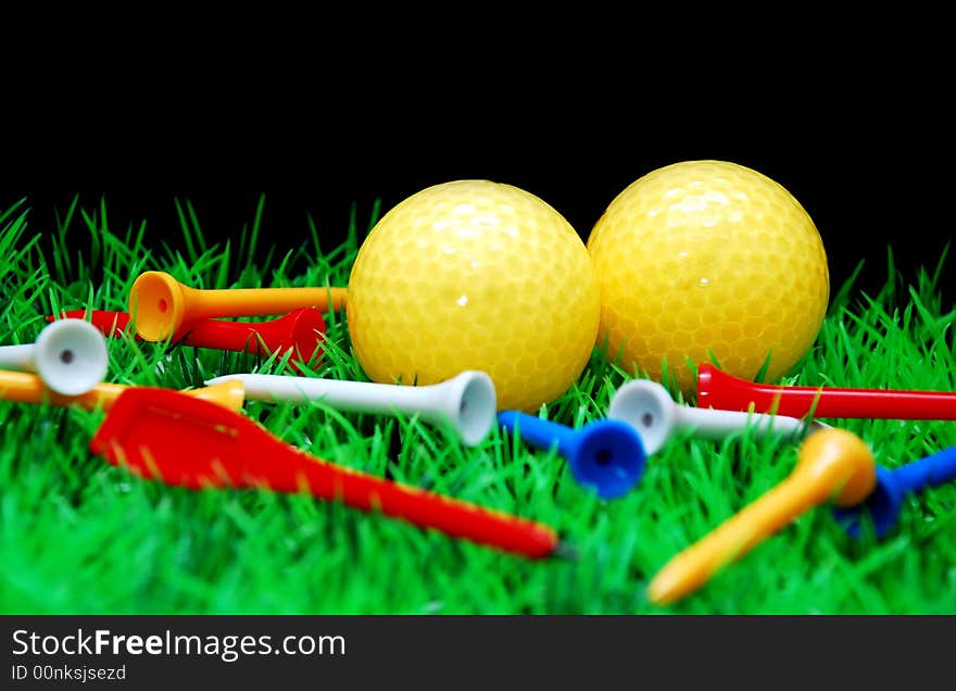 Golfball in orange tee, green fairway, isolated on black background