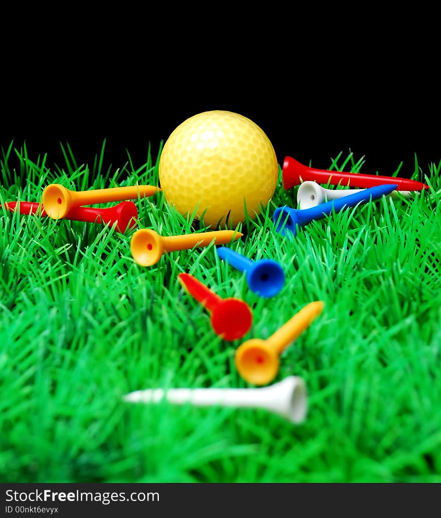 Golfball in orange tee, green fairway, isolated on black background