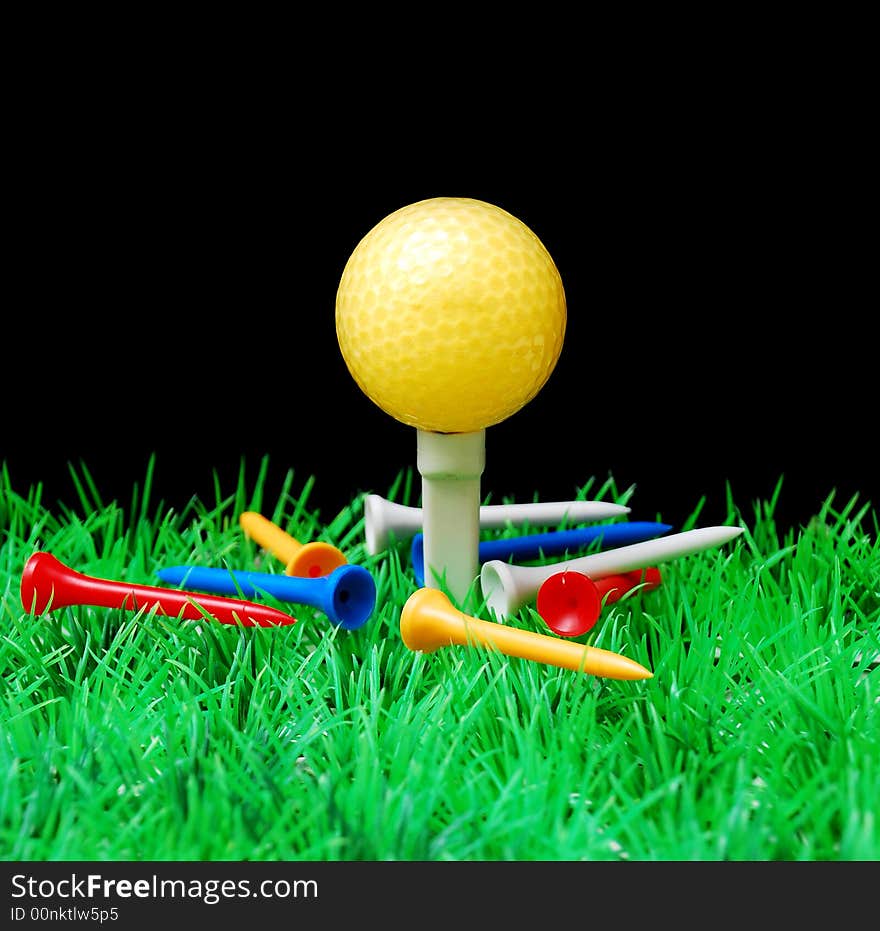 Golfball in orange tee, green fairway, isolated on black background