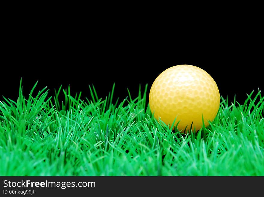 Golfball in  green fairway, isolated on black background