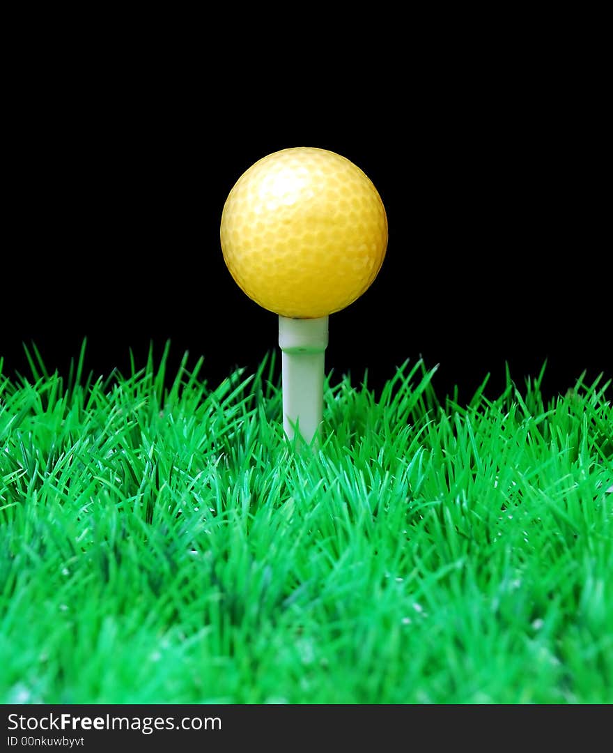 Golfball in white tee, green fairway, isolated on black background. Golfball in white tee, green fairway, isolated on black background