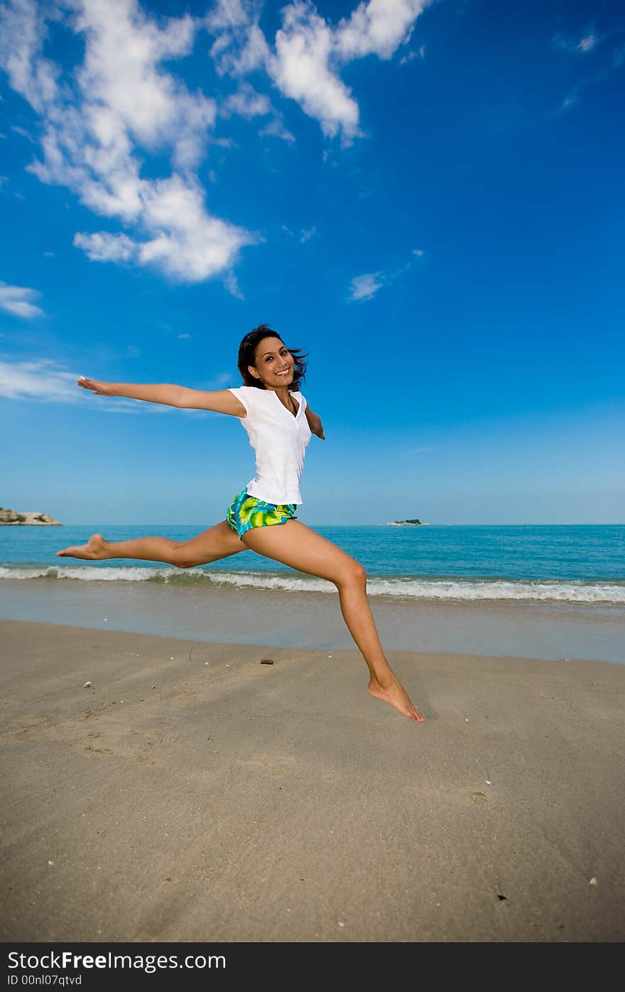 Young beautiful girl jumping happily at the beach. Young beautiful girl jumping happily at the beach