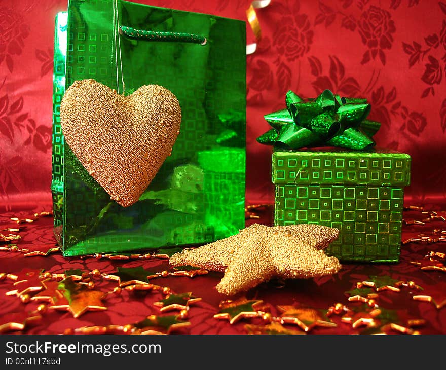 Green gift box and golden heart on celebration background