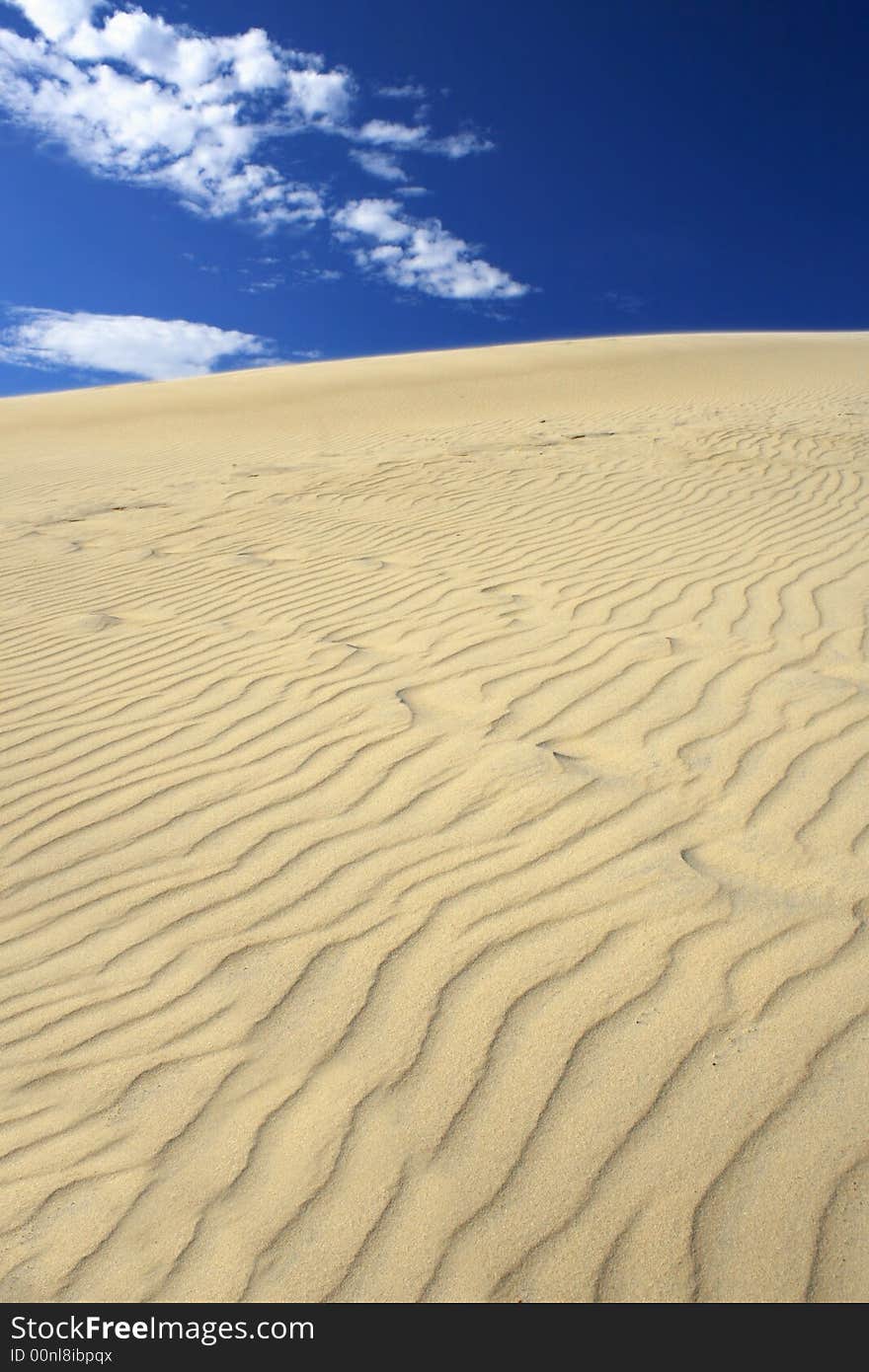 Amazing vertical view of sand dunes against deep blue sky, clear, versatile stock image. Amazing vertical view of sand dunes against deep blue sky, clear, versatile stock image