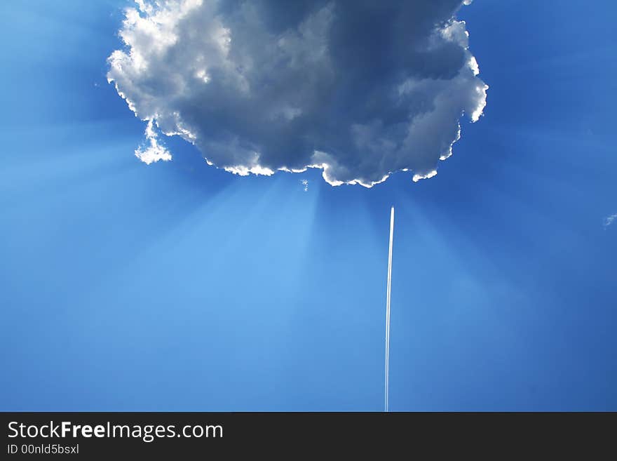 Solar beams make the way through clouds, vapor trail from an airplane. Solar beams make the way through clouds, vapor trail from an airplane