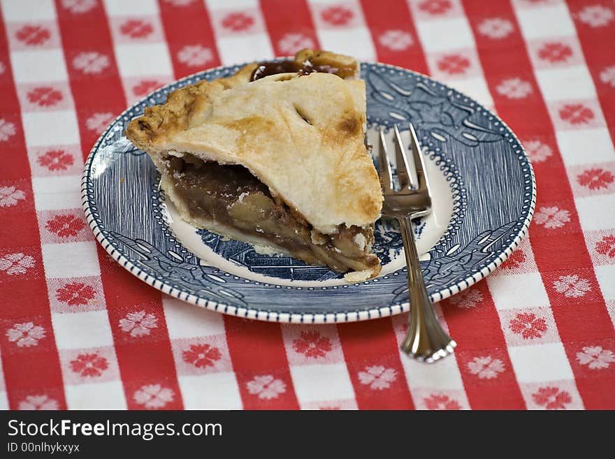 A vintage blue and white plate with slice of reak HOMEMADE apple pie.