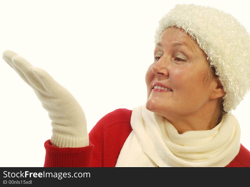 Attractive senior woman in winter fashion items looking at her hand where a gift ought to be; isolated on white. Attractive senior woman in winter fashion items looking at her hand where a gift ought to be; isolated on white