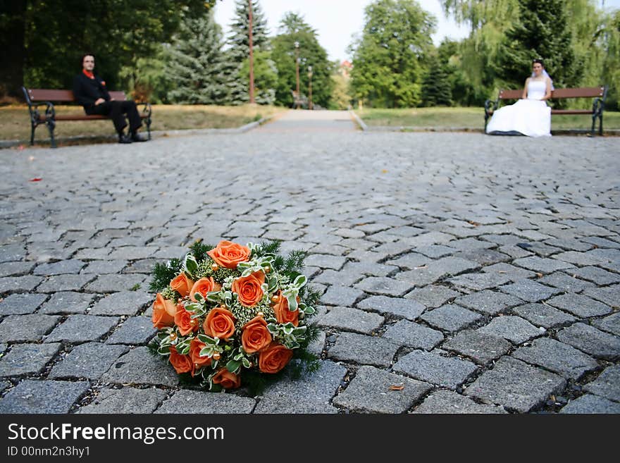 Beautiful bridal bouquet on road(blur background with young marrieds)