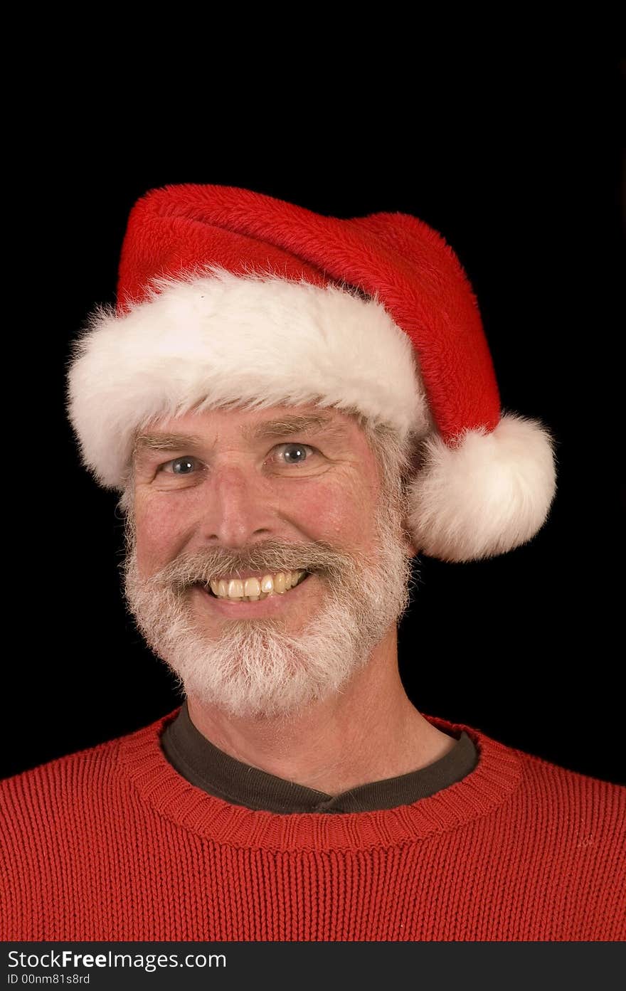 Pleasant middle-aged bearded man in a santa hat and red sweater over a black background. Pleasant middle-aged bearded man in a santa hat and red sweater over a black background