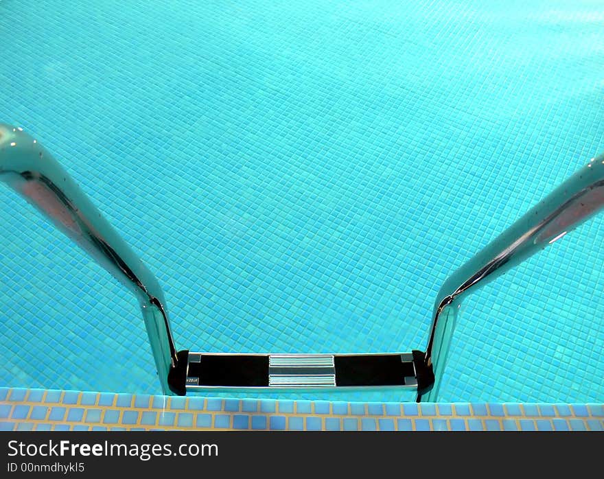 A shiny pool ladder close-up, water's surface