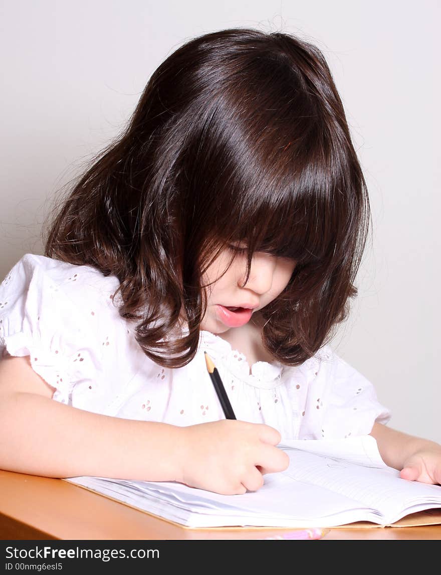 One little girl 2 years drawing in her book