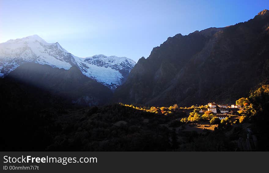 The sunlight pass through the mountain shining the small country. The sunlight pass through the mountain shining the small country.