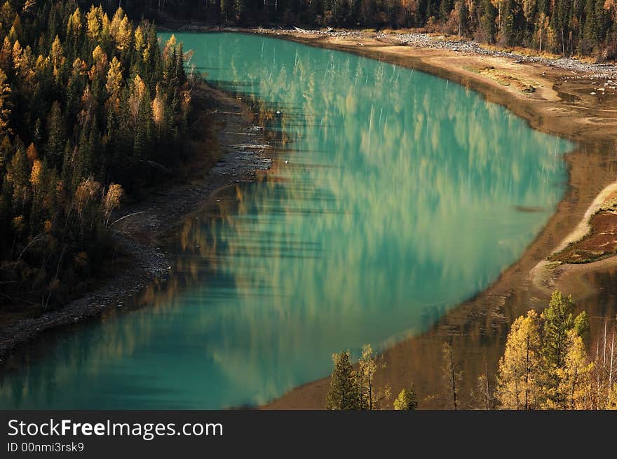 Kanas is Mongolian for The Lake in the Canyon. Here, in this picture, is the river leaving the Kanas lake. The winding river passes through some wonderful scenic lookouts. Moon Bay is one of them. The color of its water looks like jade and the currents here become slowly here. Trees on the riverside mountain are reflected by surface in the moon-like bay. Kanas is Mongolian for The Lake in the Canyon. Here, in this picture, is the river leaving the Kanas lake. The winding river passes through some wonderful scenic lookouts. Moon Bay is one of them. The color of its water looks like jade and the currents here become slowly here. Trees on the riverside mountain are reflected by surface in the moon-like bay.