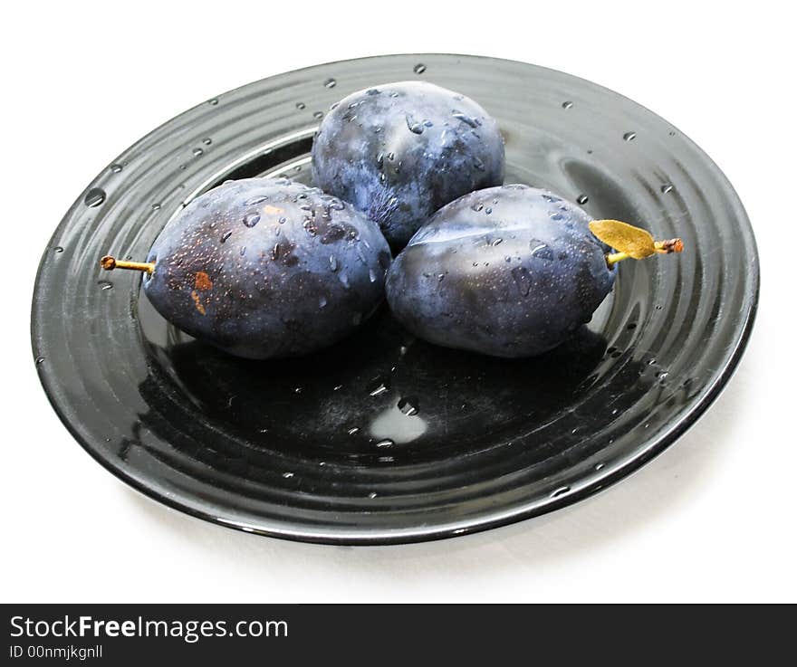 Close-up of fresh plums on a black plate